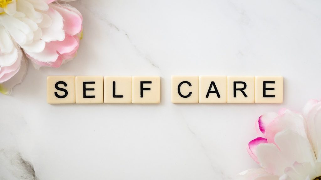 Self Care image spelled out in tiles with flowers